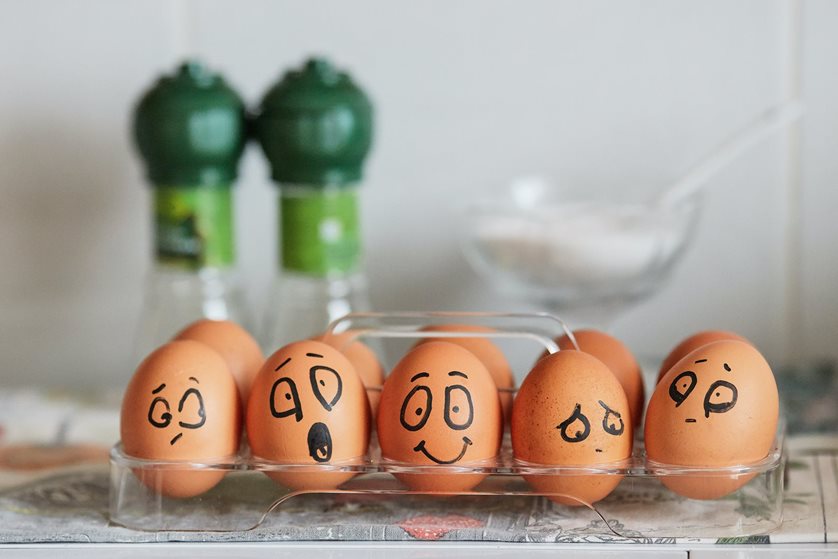 5 eggs with different expressions drawn on them with sharpie