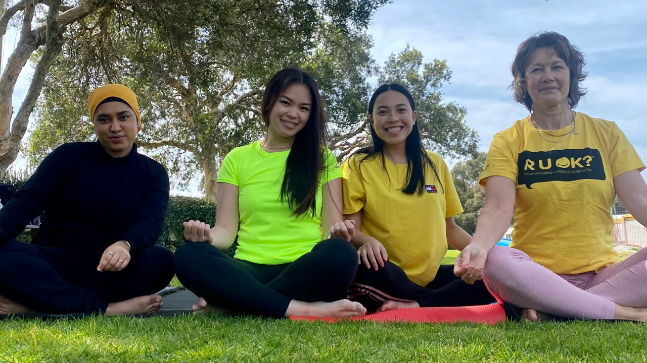 4 Skillsroad Team members wearing R U OK shirts in yoga pose
